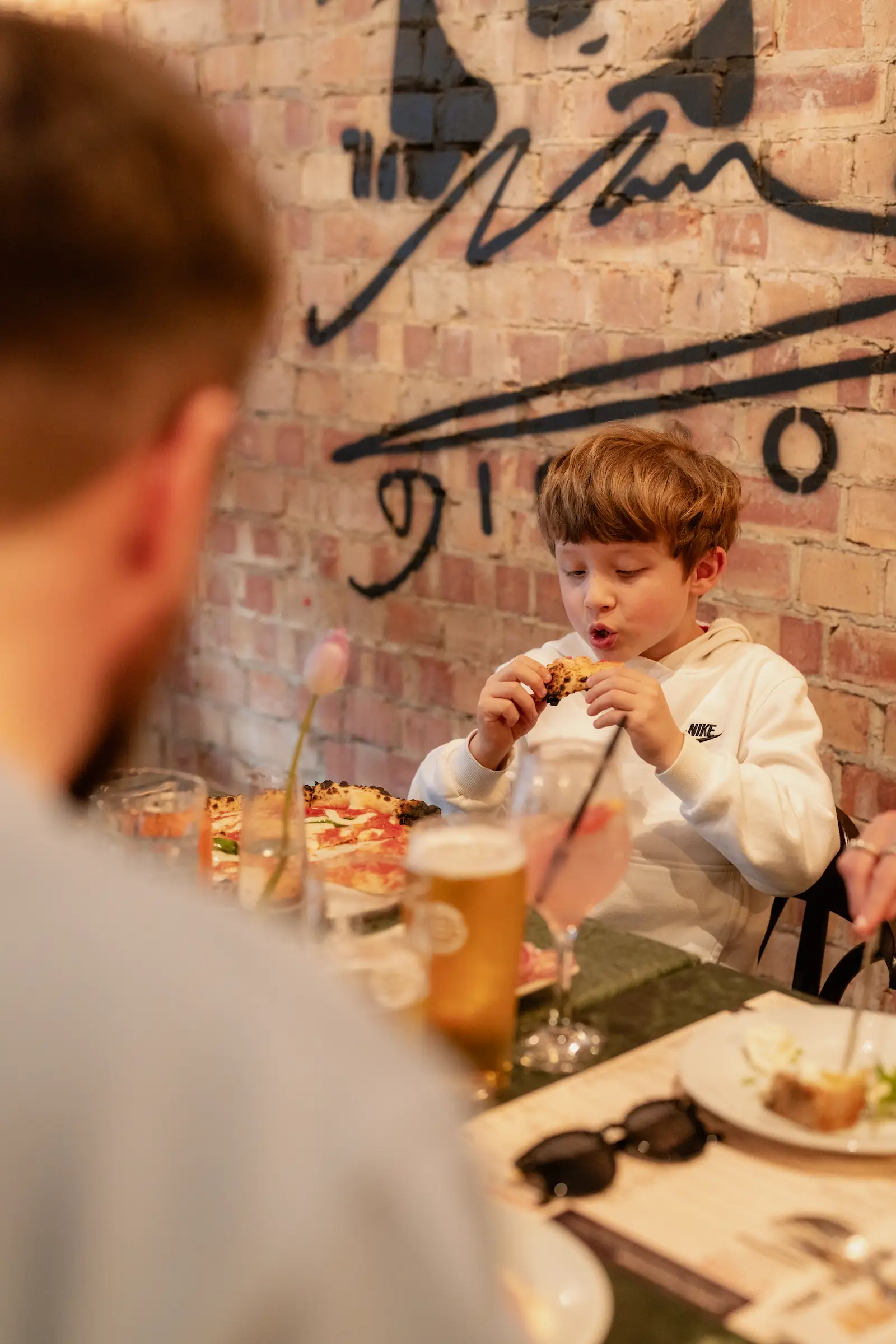 Photo of a child in the restaurant eating pizza.