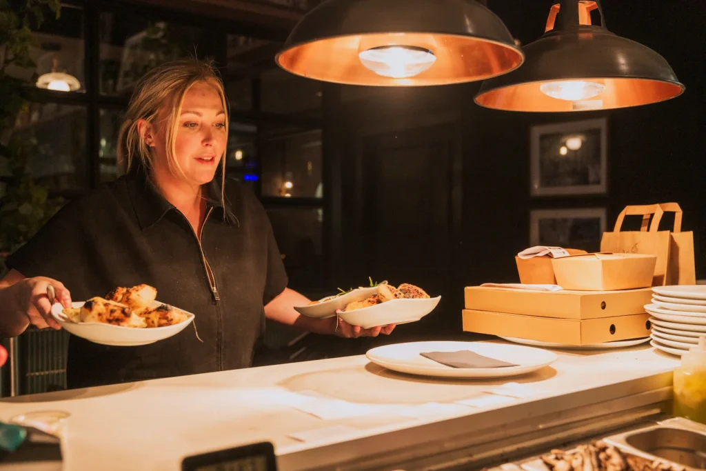 A server is taking cooked dishes out to customers.